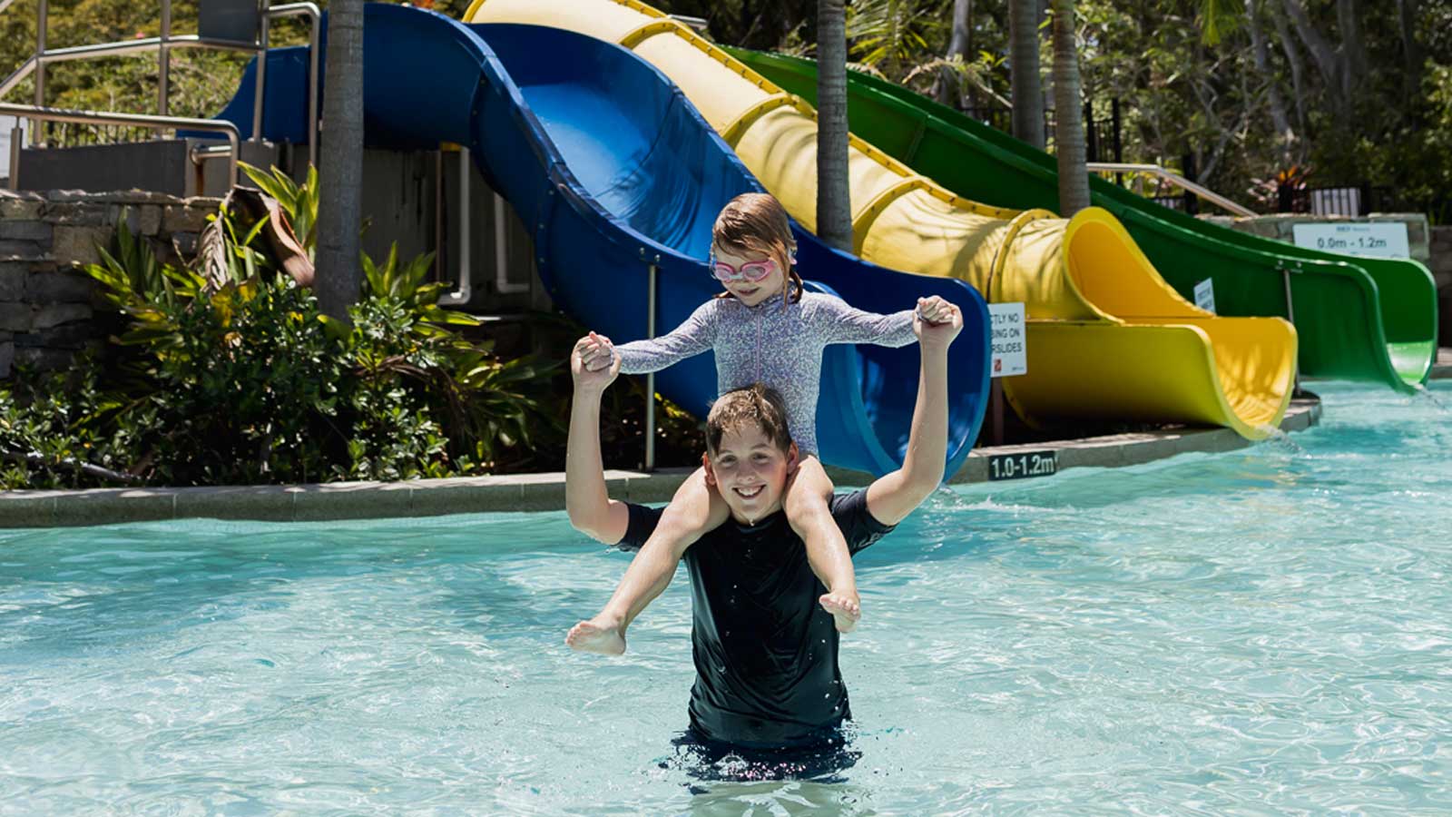 Two kids having fun in the pool near the waterslides at Royal Pines. 
