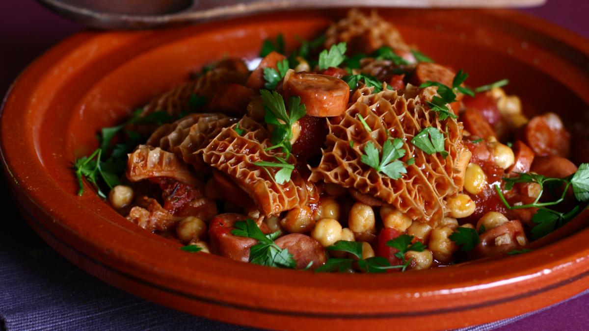A plate of tripe, chorizo sausage and chickpeas, garnished with parsley